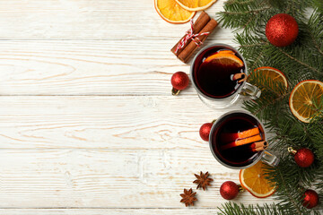 Cups of mulled wine and Christmas accessories on wooden background