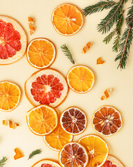 Holiday vibes. Christmas attributes. Dry oranges and cinnamon sticks in spruce branches on a wooden background