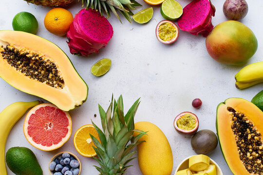Tropical fruits flat lay with mango, papaya, pitahaya, passion fruit, grapes, limes and pineapples