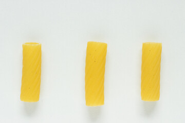 Close up of three Tortiglioni noodles on white background; isolated; italian pasta uncooked