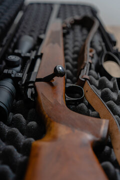 Top view of beautiful rifle with wood stock. Caliber 22 long rifle. Ammunition on table. Bolt action rifle with scope mount.