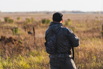 Male hunter in camouflage clothes ready to hunt with hunting rifle