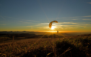 Ein fliegender Paraglider fliegt im Sonnenuntergang 