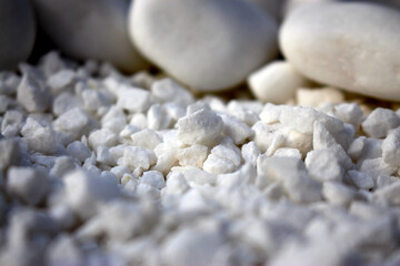 White large and small stone, crushed stone. Beautiful and smooth scattered on the surface close-up. As background