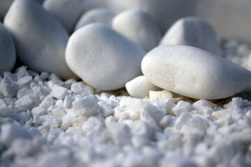 White large and small stone, crushed stone. Beautiful and smooth scattered on the surface close-up. As background