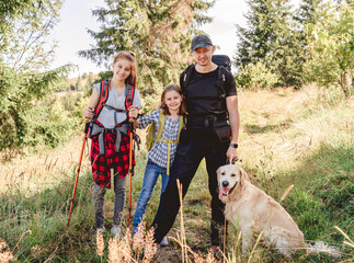 Obraz premium Father with daughters and dog hiking
