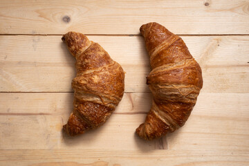 two croissants over light wooden table