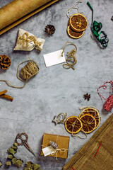 A set of items for sustainable gift wrap flat lay - paper, twine, dried oranges, spices, twigs, scissors, tags, ribbons. Eco-friendly gift wrapping. Flat lay, copy space, top view