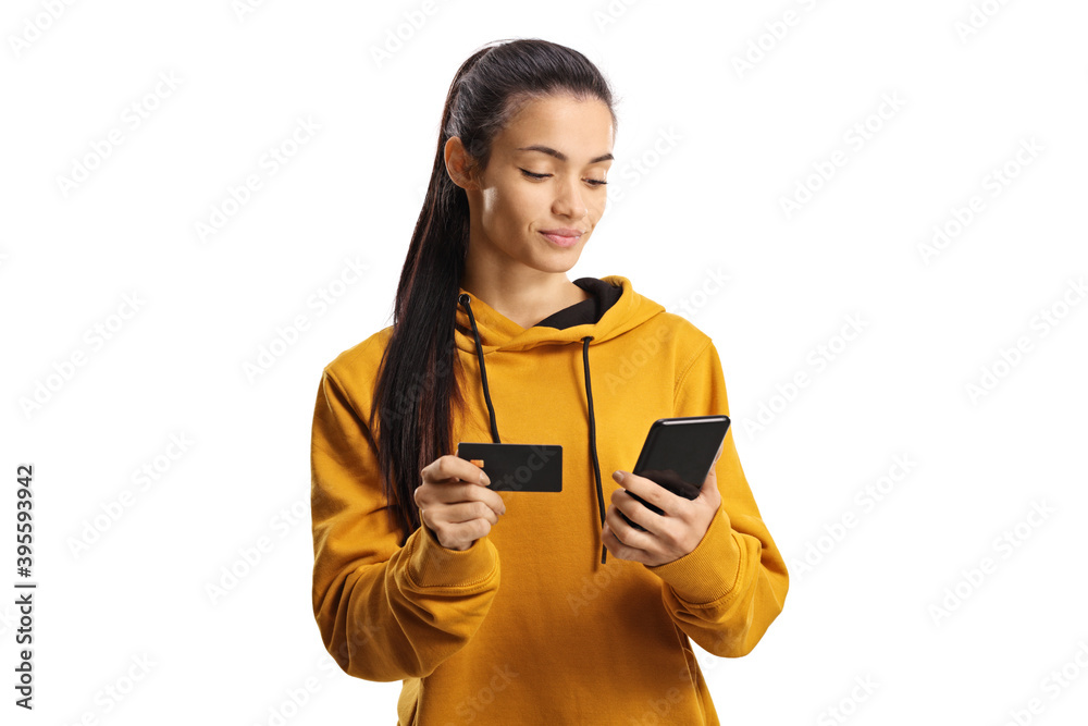 Wall mural young woman shopping online with a credit card and a smartphone