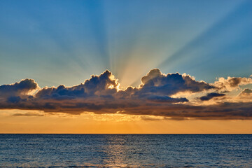 typical scenery between clouds and sea with warm light at sunrise on a clear autumn day