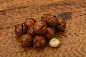 Brown macadamia nut heap over background