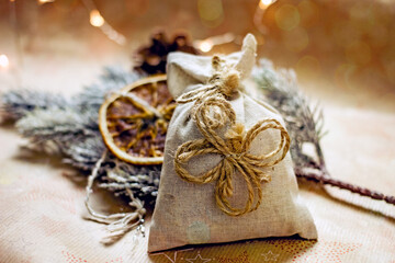 Christmas gift in sustainable gift wrap. Cotton bag decorated with a twine bow. Eco-friendly Christmas gift wrapping, copy space - Powered by Adobe