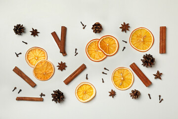 Fototapeta na wymiar Cinnamon, orange slices and cones on white background