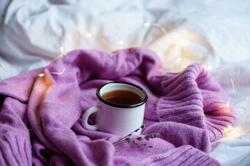 Obraz na płótnie Canvas knitted sweater and cup of tea . the concept of tranquility, warmth and comfort. hygge at home