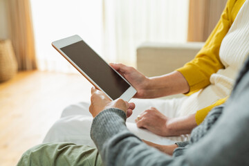 リビングでタブレット端末を使う老夫婦