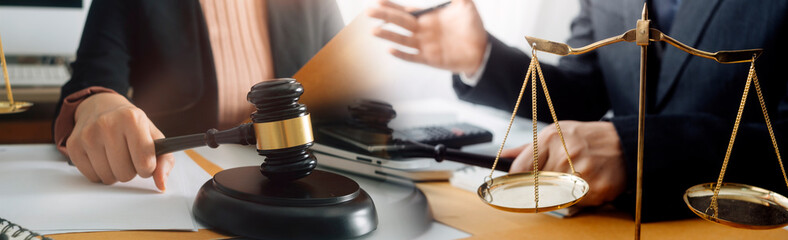 Business and lawyers discussing contract papers with brass scale on desk in office. Law, legal services, advice, justice and law concept