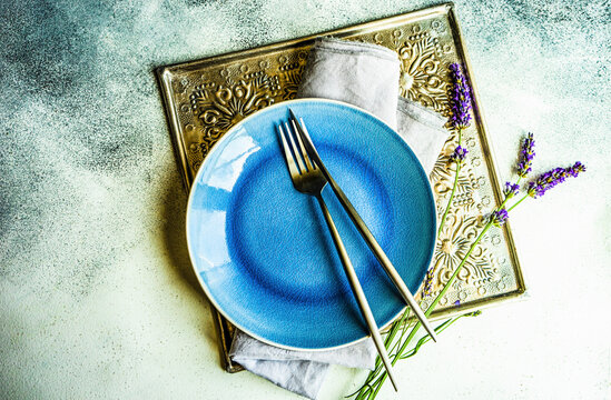 Summer time table set with minimalistic stoneware and cutlery decorated with fresh lavender flowers