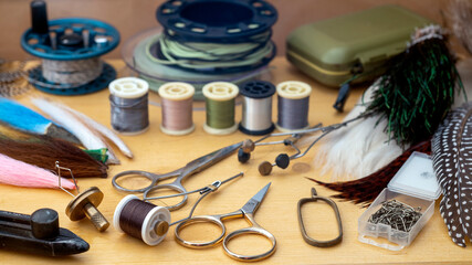 Fishing fly tying materials and tools on a wooden table