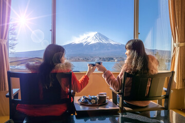 Japanese family relaxing in their room.Bedroom has a view of Mt Fuji.Fuji view outside the window.