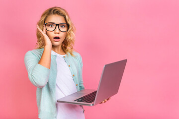 Excited little blonde teenager kid girl 12-13 years old isolated over pink background. Childhood lifestyle concept. Mock up copy space.