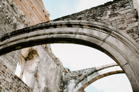 Low angle shot of ancient stone arches under a blue sky