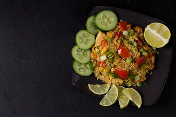 Asian khao pad kung fried rice with vegetables, meat, egg, fresh cucumbers and tomatoes