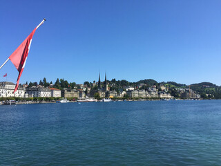 view of cityscape and swiss flag near the river Reuss, Lucerne, Switzerland