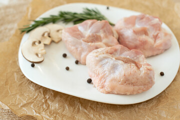 Raw turkey chicken tail on a plate on a white background. Isolate. Copy space.