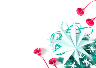 Christmas, New Year composition. A large paper star is located along with fir branches on a white background. The template is decorated with red bells and white bows. Flat lay, top view, copy space.