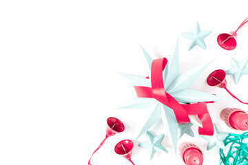 Christmas, New Year composition. A large paper star is placed along with red bells and candles on a white background. Flat lay, top view, copy space.