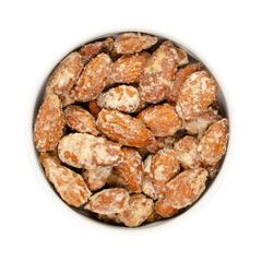 Candied almonds in a white bowl. Homemade, in a special way cooked almonds, whole nuts coated in crunchy sugar. Sold at Christmas markets. Close-up, from above, isolated over white, macro food photo.