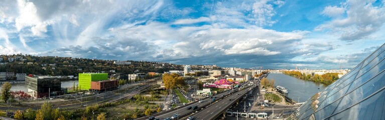 Obraz premium Topview of the southern entrance to Lyon, the railway line, the A7 motorway and the modern Confluences district. The winter fun fair is already showing its joyful colors.
