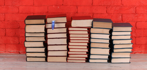 stack of library books, red brick wall