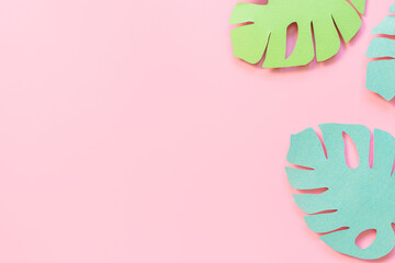 Paper monstera leaves on a pink background. Creative paper art. Background bright summer image.