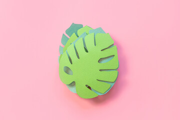 Paper monstera leaves on a pink background. Creative paper art. Background bright summer image.