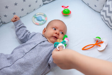 mom tries to give a pacifier to naughty babe