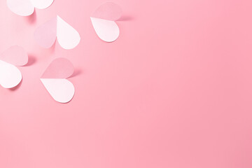 Pink paper hearts on a pink background. Concept of romance, love, valentine's day. Minimalism, copy space, paper art.