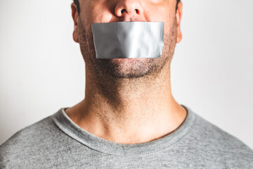 Censorship concept. Man is silenced with Grey adhesive tape on his mouth