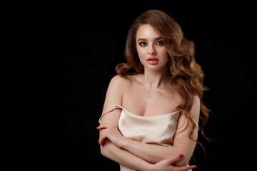 Naklejka premium Beauty portrait of elegant young woman. Glamour makeup. Face of the beautiful woman with long brown curly hair posing at studio over dark background. Sensual portrait.