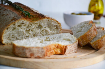 Sliced bread Ciabatta and rosemary on wooden on white background