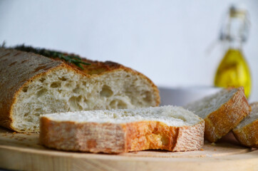 Sliced bread Ciabatta and rosemary on wooden on white background
