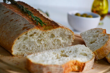 Sliced bread Ciabatta and rosemary on wooden on white background
