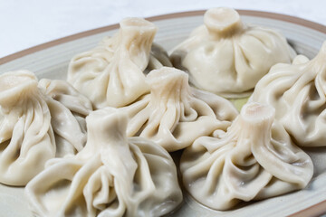 Georgian dumplings Khinkali with meat on white plate.