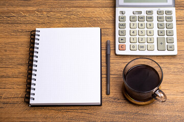 View from above.eye glasses,pen,notebook,calculator, and cup of coffee on office desk with copy space.