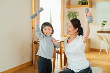 室内で運動する祖母と孫