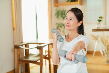 室内で運動するシニア女性