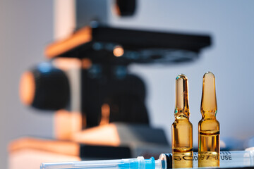 Medical vial with medication near microscope photo