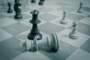 White resigns in a game of chess and places his king flat on the chessboard