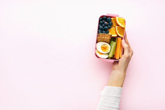 Woman holding lunch box with healthy nutritious meal