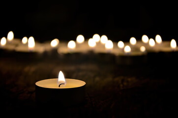 Many small christmas candles burning at dark. Shallow depth of field, selective focus